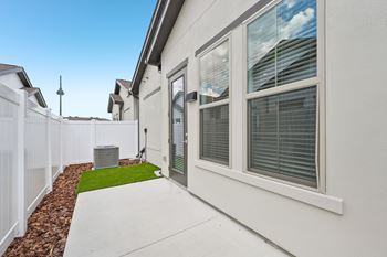 A white house with a green lawn in front at The Hadley - North Port, FL Apartments, North Port, Florida
